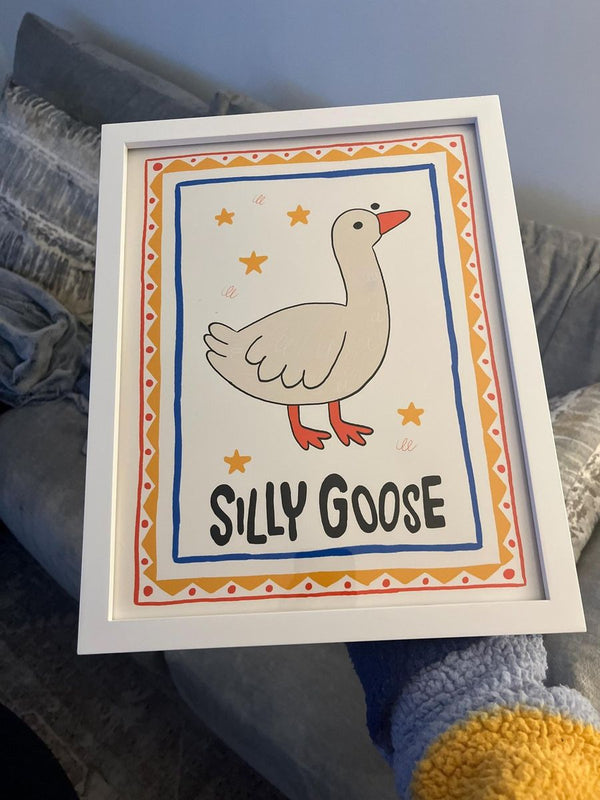 Silly Goose print in a white frame with a hand-drawn red and gold border