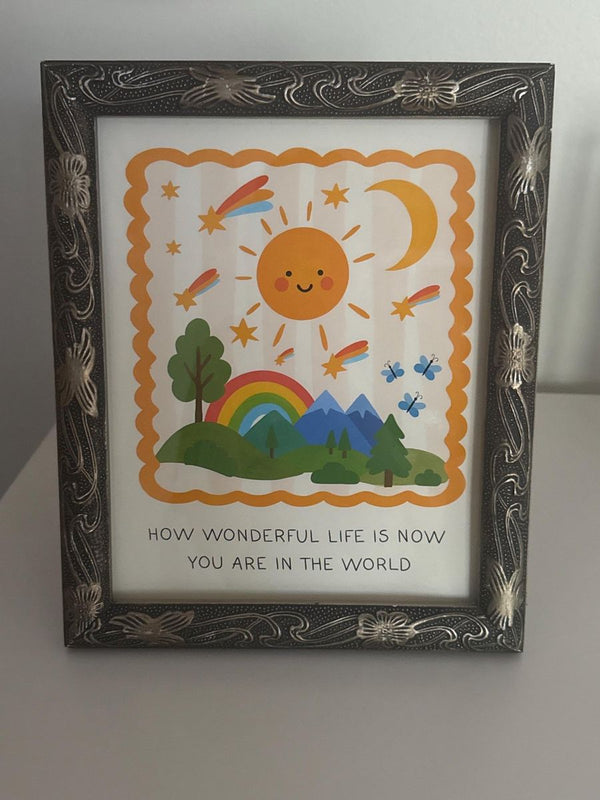 How Wonderful Life Is Now You're In The World print in an ornate silver frame on a white dresser